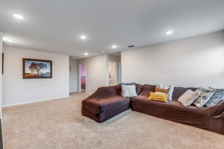 Living area with attic access, light carpet, and recessed lighting