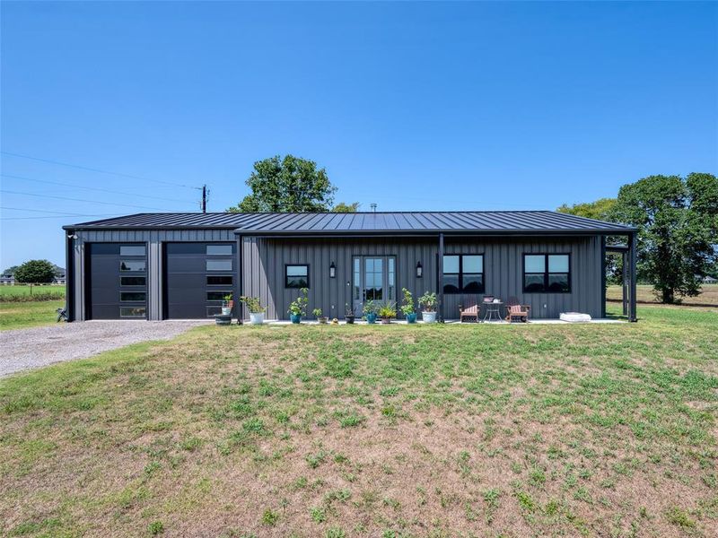 View of front facade with board and batten siding, a front yard, and a standing seam roof View of front facade with board and batten siding, a front yard, and a standing seam roof