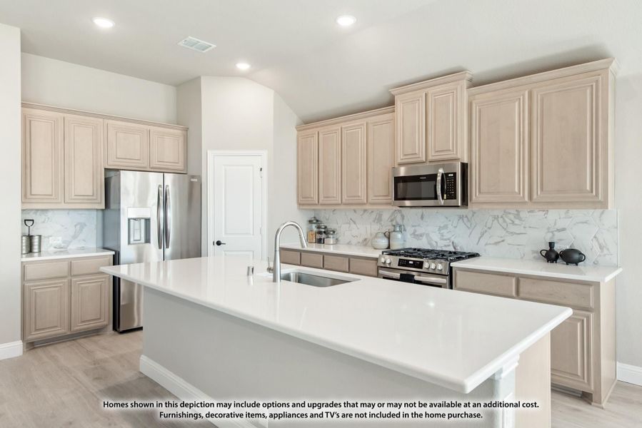 Kitchen with light wood cabinets, white island with sink, marble backsplash, and stainless steel appliances Kitchen with light wood cabinets, white island with sink, marble backsplash, and stainless steel appliances
