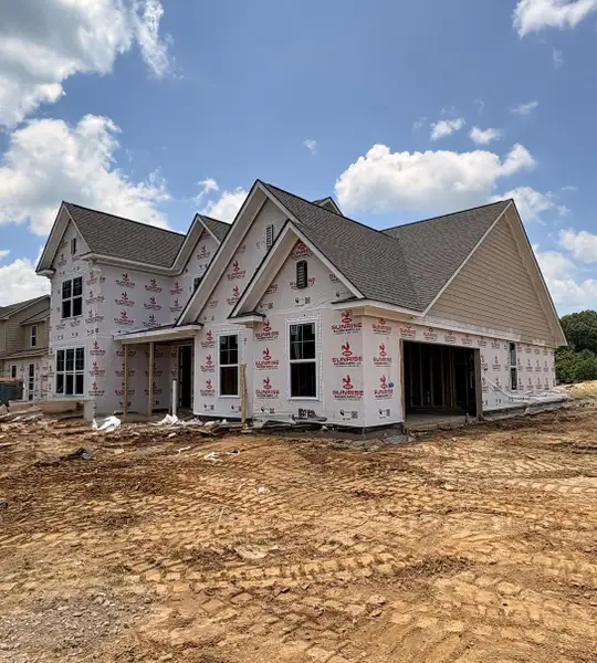 New construction with a multi-gabled roofline and exposed foundation New construction with a multi-gabled roofline and exposed foundation