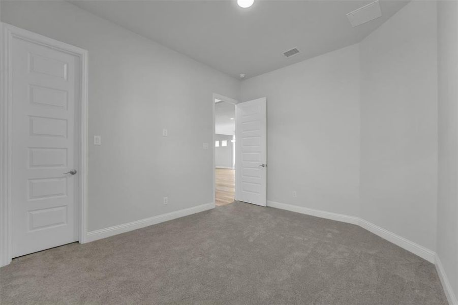 Empty room featuring light carpet and baseboards