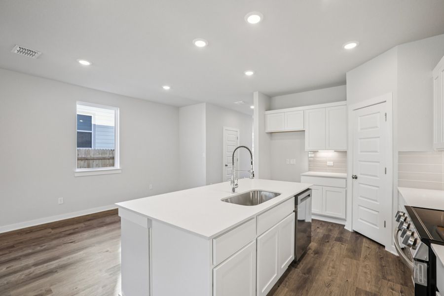A kitchen with white cabinets.