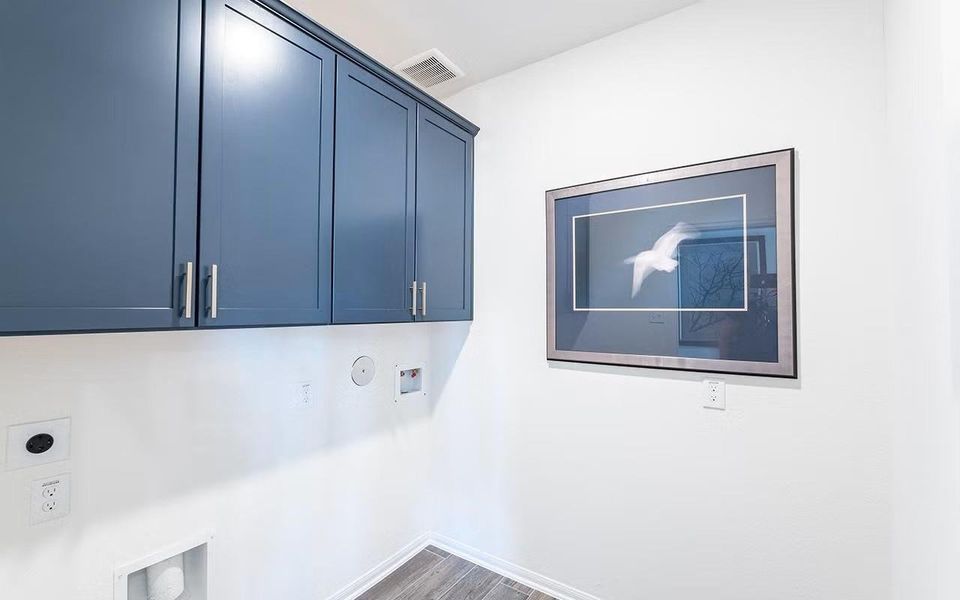 Functional utility room featuring built in cabinetry and dedicated washer and dryer connections, providing a clean and practical space for everyday household tasks. **Photos are representative only and may vary as built.**