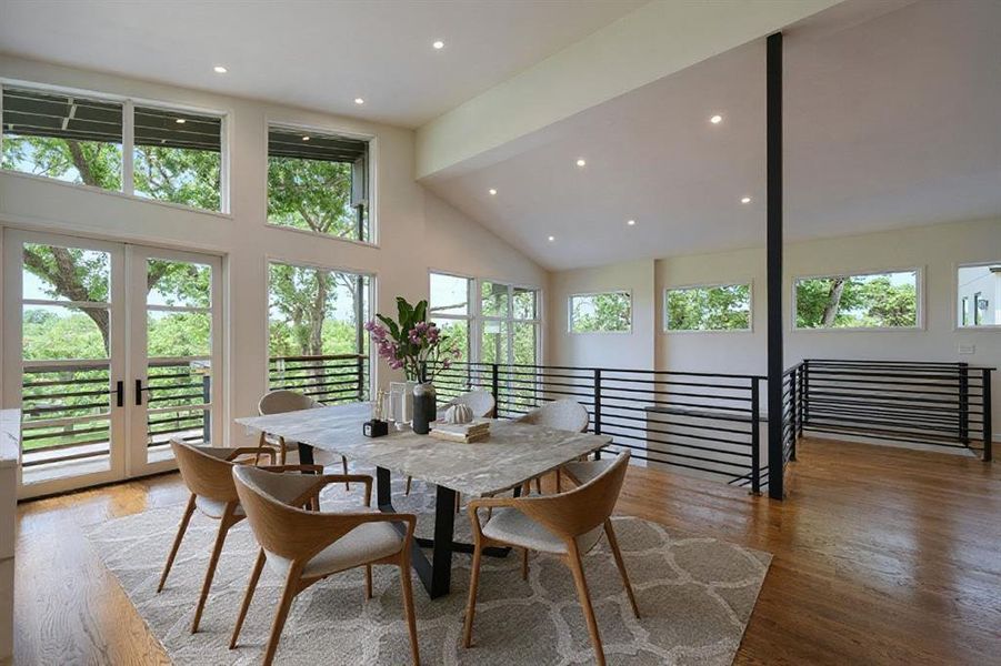 Dining space with high vaulted ceiling, recessed lighting, and wood finished floors