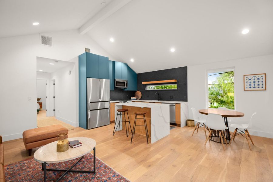 Kitchen featuring a center island, stainless steel appliances, a kitchen breakfast bar, light wood-style floors, and recessed lighting