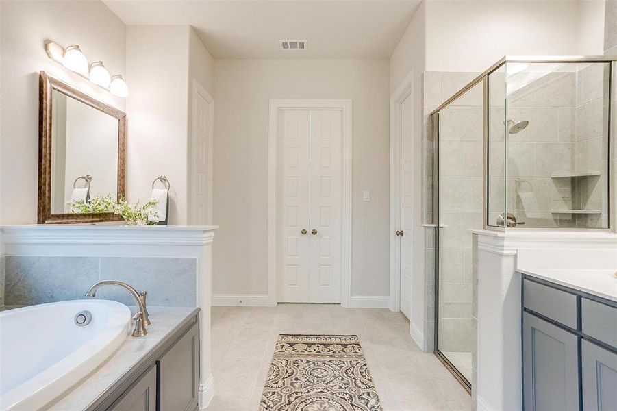 Bathroom featuring vanity, shower with separate bathtub, and tile patterned flooring