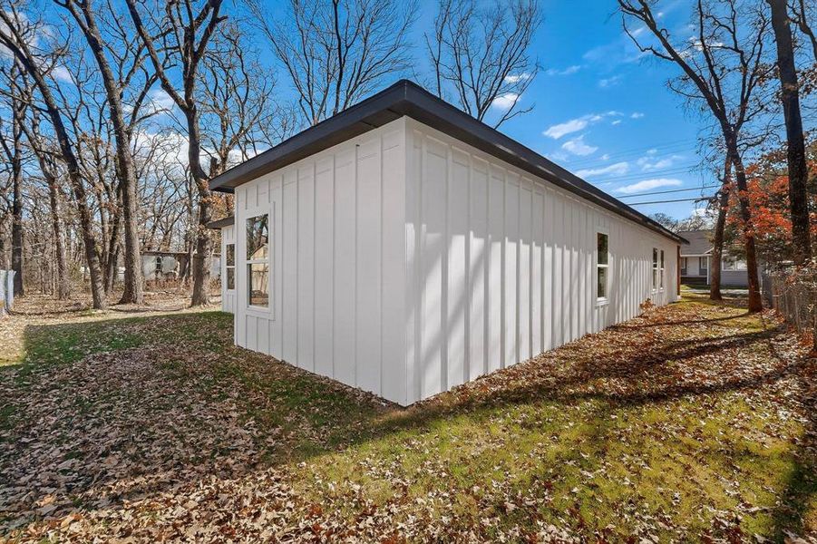 View of side of property with board and batten siding and a yard