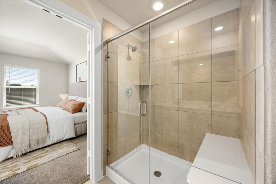 Step into the beautifully designed primary bath, featuring an expansive glass-enclosed shower and elegant tile surround. Sleek finishes and a spacious layout create a spa-inspired retreat that perfectly complements the tranquility of the adjoining bedroom.