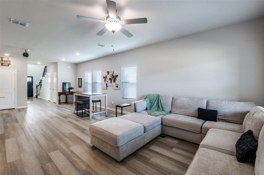 Living area with ceiling fan, wood finished floors, and recessed lighting