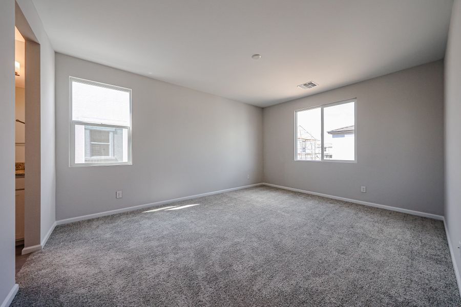 A room with a carpet and windows.