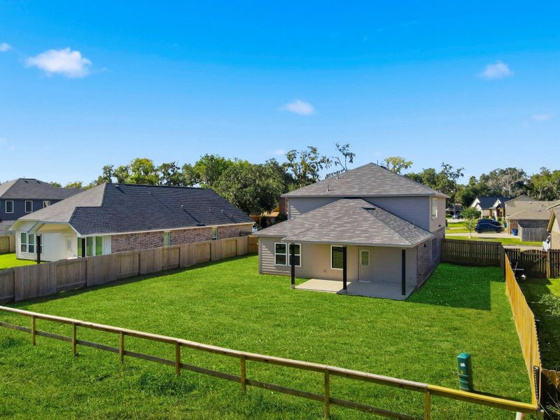 Another view highlighting the impressive fenced backyard at dusk, where the warm glow of the evening sun casts a peaceful light over the expansive space. Ideal for enjoying quiet evenings or hosting cozy gatherings, this serene outdoor setting captures the beauty of lakeside living.
