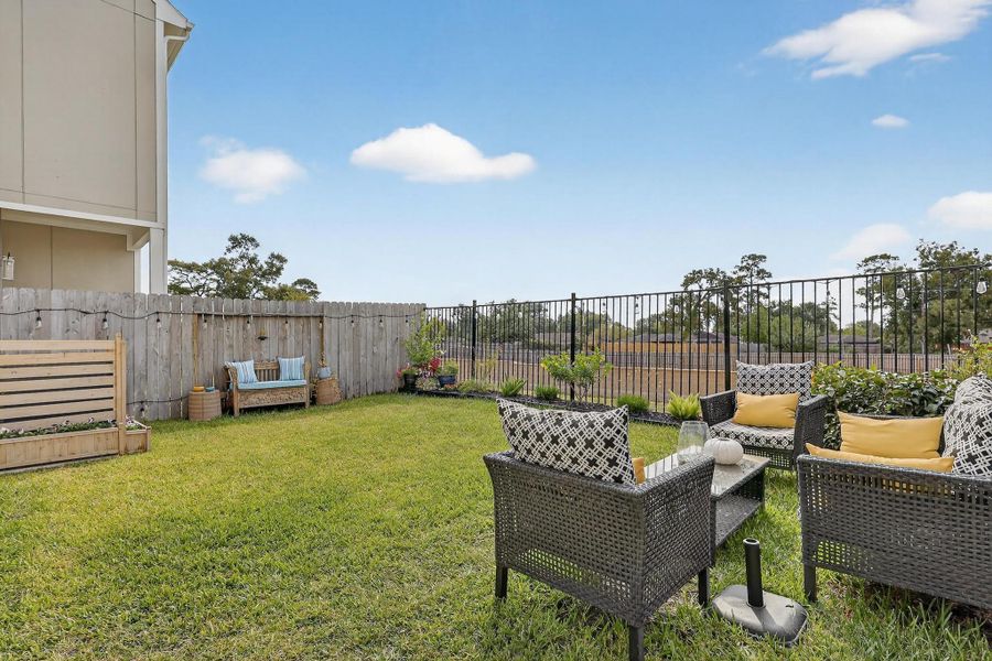 Private, fully fenced backyard with a mix of wood and wrought-iron fencing that opens to a peaceful green backdrop. Private, fully fenced backyard with a mix of wood and wrought-iron fencing that opens to a peaceful green backdrop.