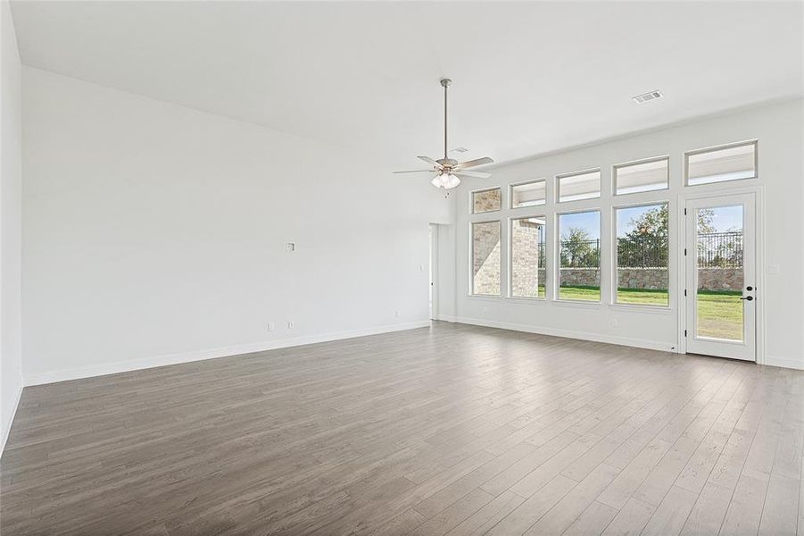 Unfurnished living room featuring dark wood-type flooring and ceiling fan