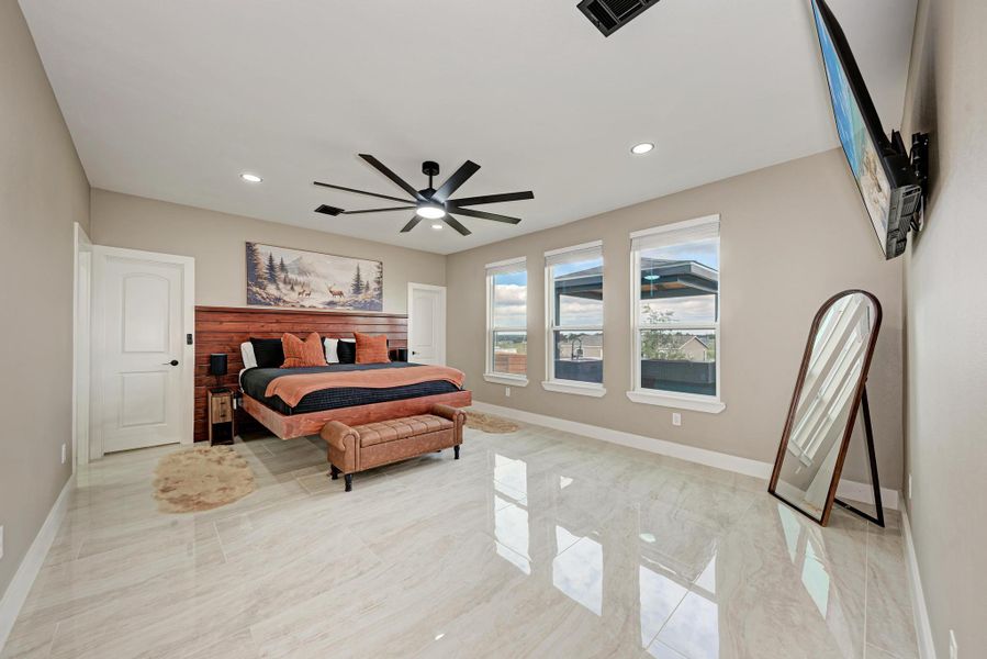 Gleaming polished tile floors reflect light in this serene main-level bedroom retreat. Gleaming polished tile floors reflect light in this serene main-level bedroom retreat.