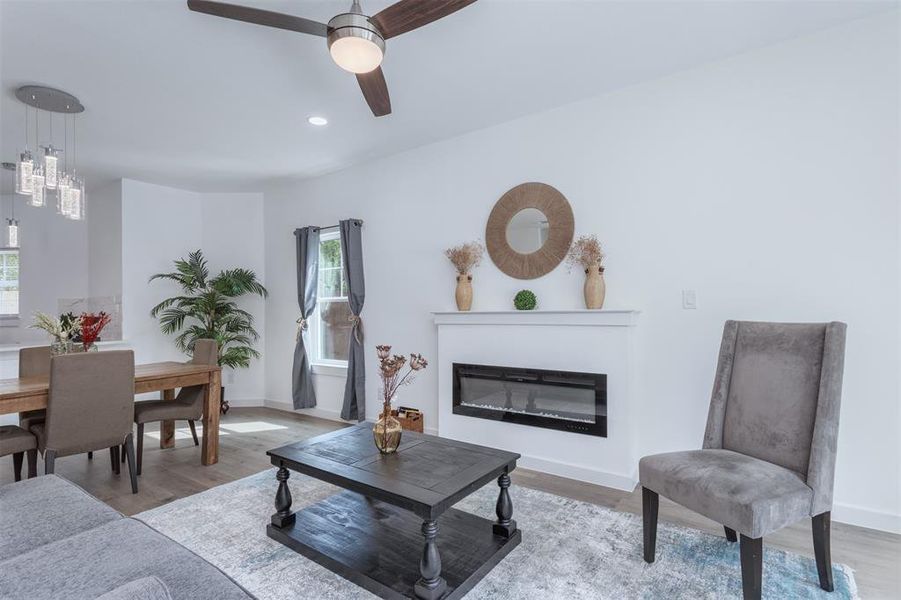 Living room featuring light hardwood / wood-style flooring, ceiling fan, and plenty of natural light