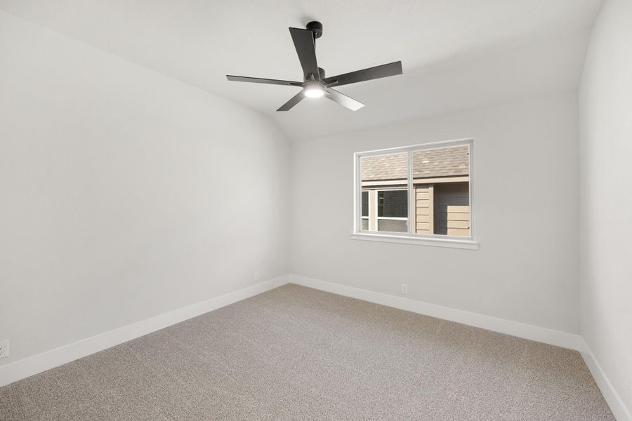 Empty bedroom with gray carpet, white walls, black ceiling fan, and single window