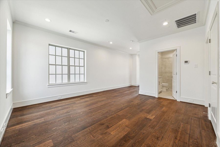 Third-floor game room, access to balcony through glass door on left, secondary bedroom through middle door on right.