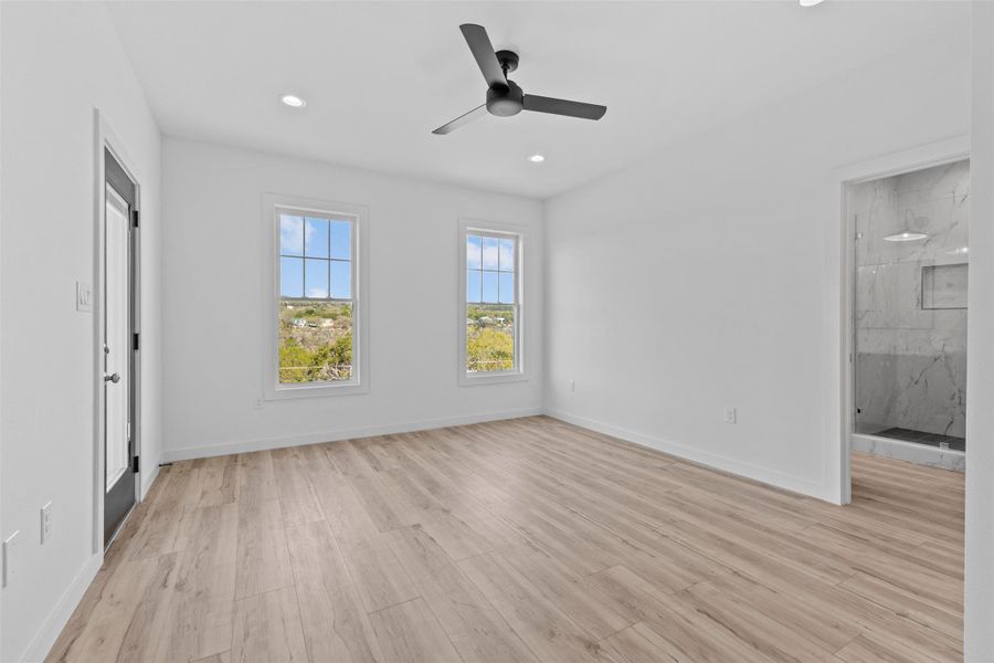 Unfurnished bedroom with ceiling fan, light wood-type flooring, recessed lighting, and ensuite bathroom