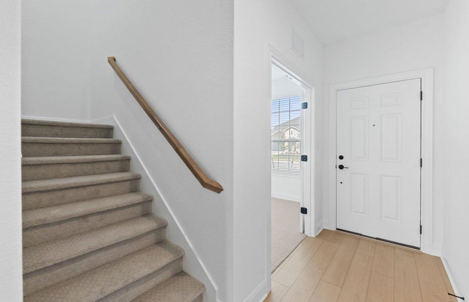 Foyer featuring stairs and light wood-type flooring Foyer featuring stairs and light wood-type flooring