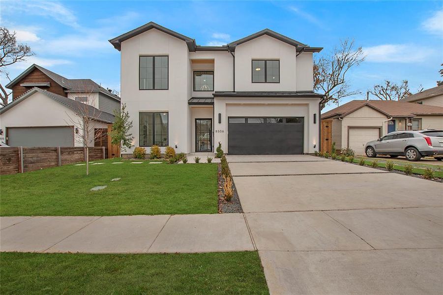 View of front of home featuring a front lawn and a garage