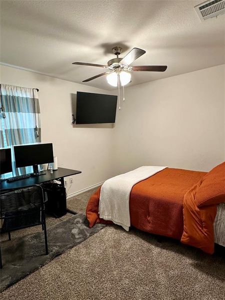 Bedroom with carpet, a textured ceiling, a ceiling fan Bedroom with carpet, a textured ceiling, a ceiling fan