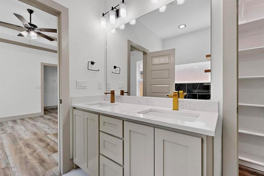 Bathroom with light wood-style floors, double vanity, and a closet