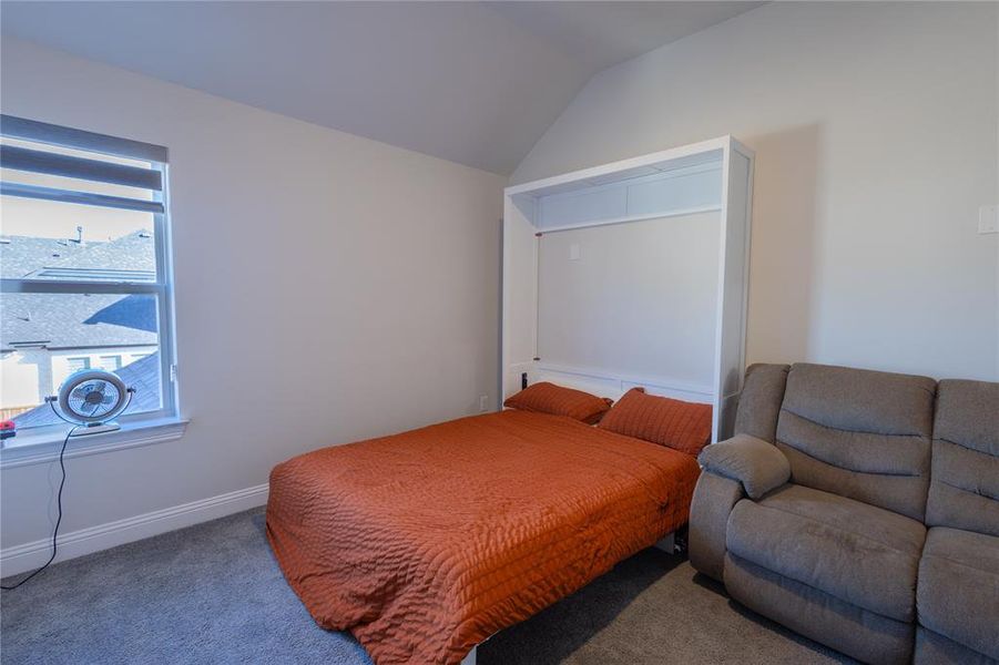 Bedroom with vaulted ceiling and carpet