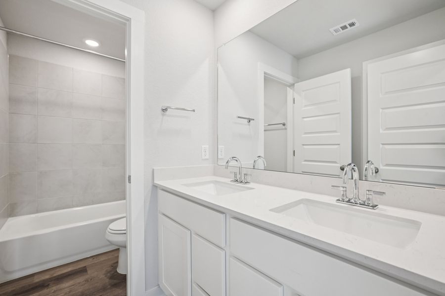 A bathroom with a tub sink and toilet.