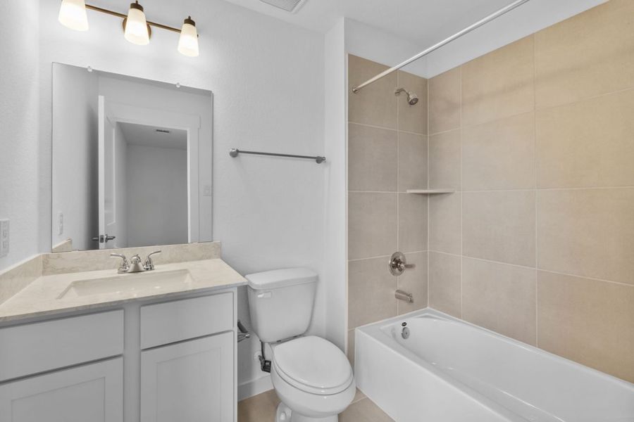 Image of a bathroom with a vanity, large mirror and a a shower with beige tiles and a white tub Image of a bathroom with a vanity, large mirror and a a shower with beige tiles and a white tub