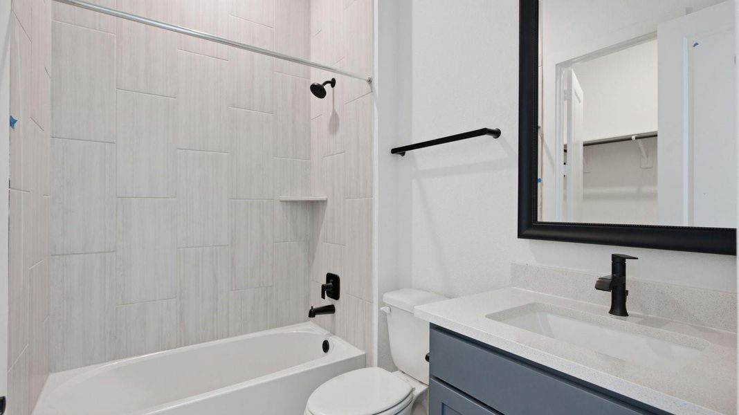 A secondary bathroom with a standing tub, one sink vanity, and a window for natural lighting