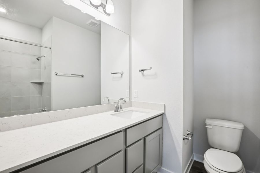 A bathroom with a sink toilet and shower. A bathroom with a sink toilet and shower.