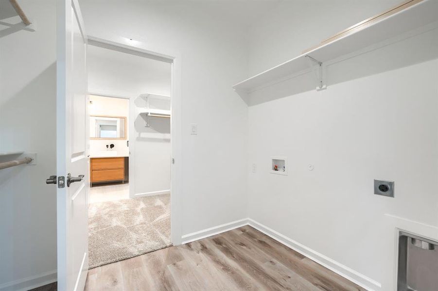 Laundry room with light wood finished floors, washer hookup, electric dryer hookup, and hookup for a gas dryer