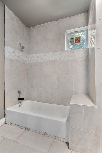 Full bathroom with shower / tub combination and tile patterned floors Full bathroom with shower / tub combination and tile patterned floors