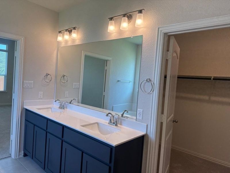 Double vanity with white countertops, undermount sinks, and chrome faucets Double vanity with white countertops, undermount sinks, and chrome faucets