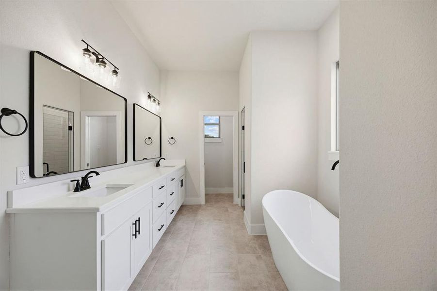 Spacious bathroom featuring a dual vanity with white cabinetry, matte black hardware, and an undermount sink