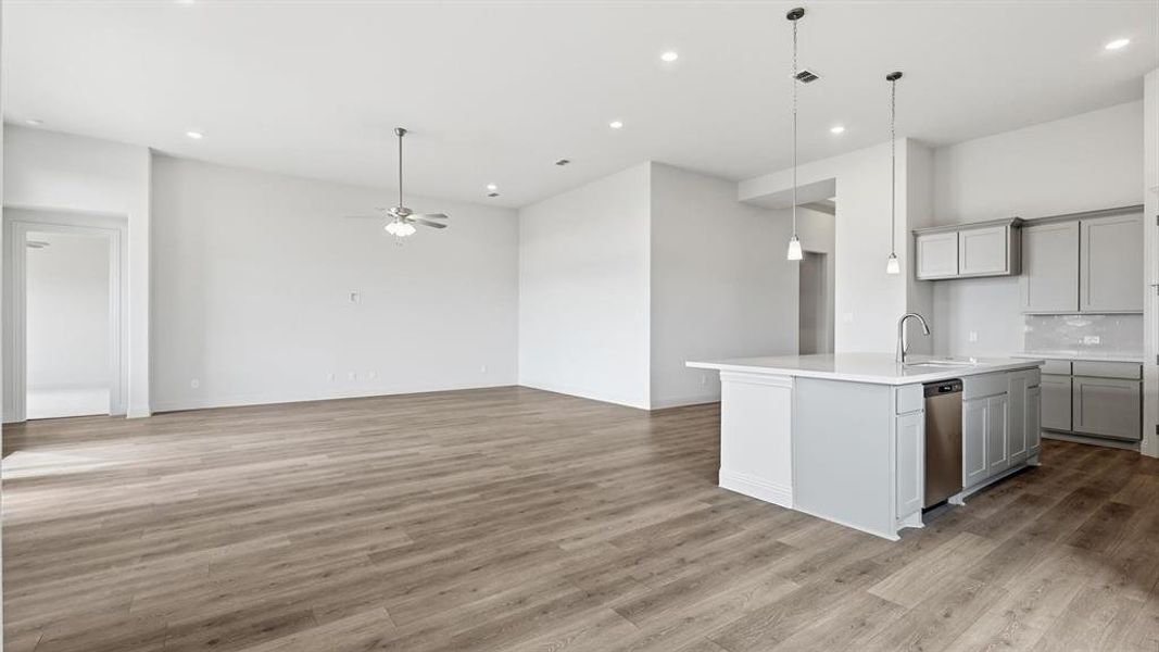 Open-concept living area featuring wood-finish flooring, recessed lighting, and a ceiling fan