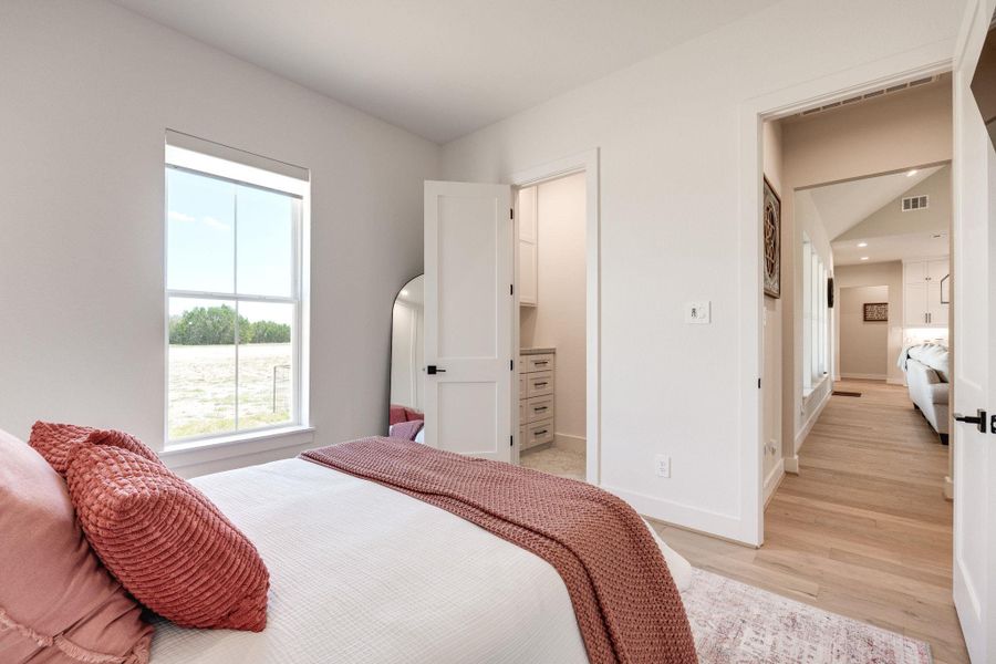 Bedroom featuring a spacious closet and light wood finished floors