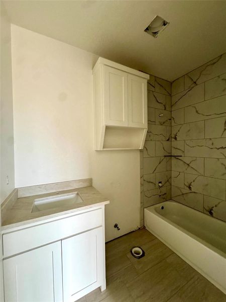 A well-appointed bath features a sleek vanity and tiled shower.