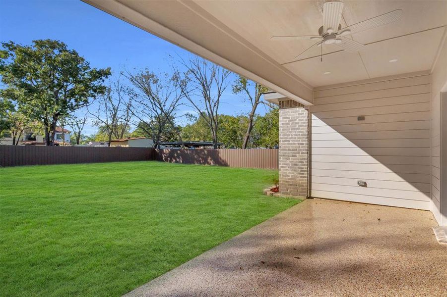 Fenced backyard with a patio and ceiling fan