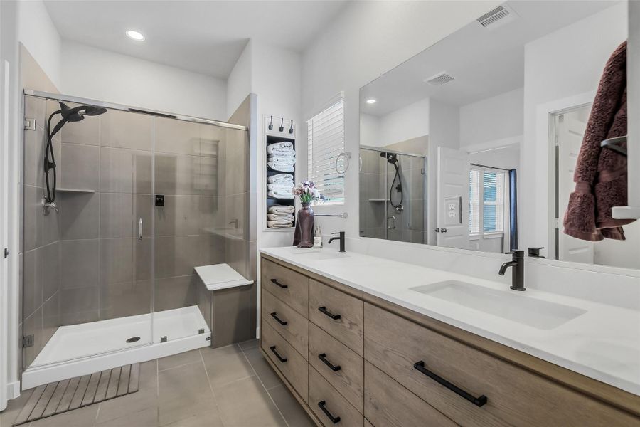 Elegant primary bathroom with upgraded dual vanity, generous counter space, modern cabinetry, and designer lighting.