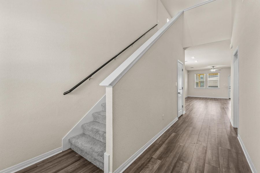 Staircase with wood finished floors and a ceiling fan Staircase with wood finished floors and a ceiling fan