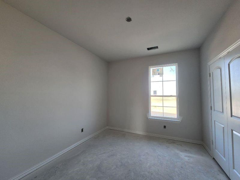Unfurnished room with baseboards and unfinished concrete flooring