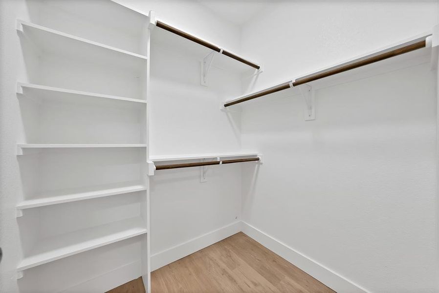 Walk in closet with light wood-type flooring