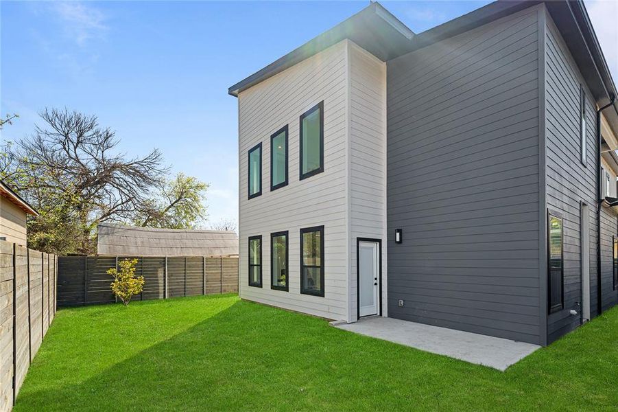 Rear view of property with a fenced backyard and a patio