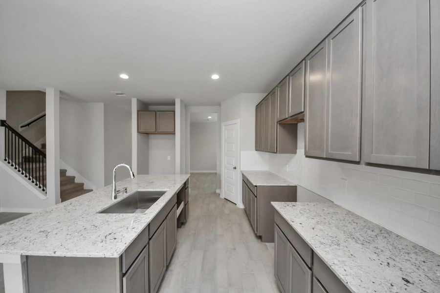 This generously spacious kitchen is a dream realized! With a massive granite island, highceilings, soft close cabinets, granite countertops, stainless steel appliances, a sleek tilebacksplash, recessed lighting, and an extended counter area, it offers both style andpracticality. Sample photo of completed home with similar floor plan. Actual colors and selections may vary. This generously spacious kitchen is a dream realized! With a massive granite island, highceilings, soft close cabinets, granite countertops, stainless steel appliances, a sleek tilebacksplash, recessed lighting, and an extended counter area, it offers both style andpracticality. Sample photo of completed home with similar floor plan. Actual colors and selections may vary.