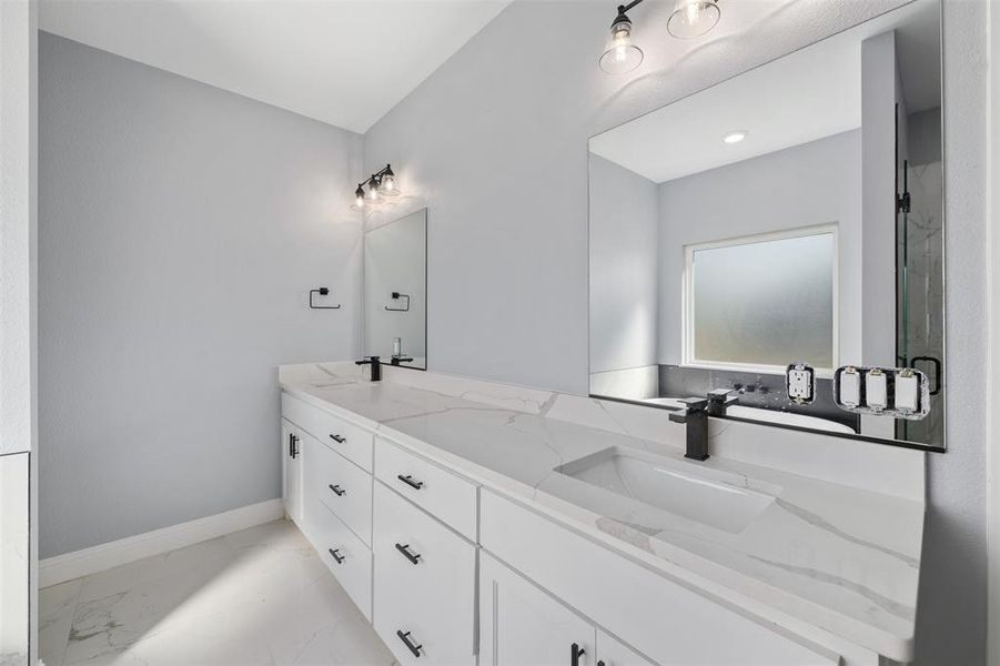 Full bath with double vanity, light marble finish flooring, and an enclosed shower Full bath with double vanity, light marble finish flooring, and an enclosed shower