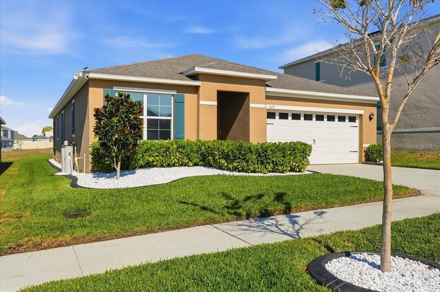 Front exterior of a new home in Eden Hills, Lake Alfred, FL, highlighting curb appeal (Image 2). Front exterior of a new home in Eden Hills, Lake Alfred, FL, highlighting curb appeal (Image 2).