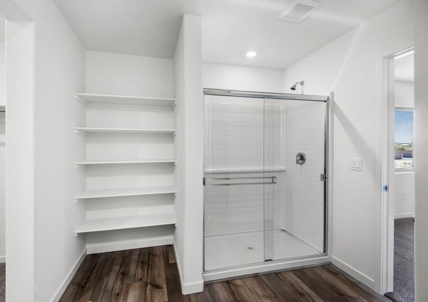 The master bathroom provides plenty of space with built in shelving and a walk in shower.