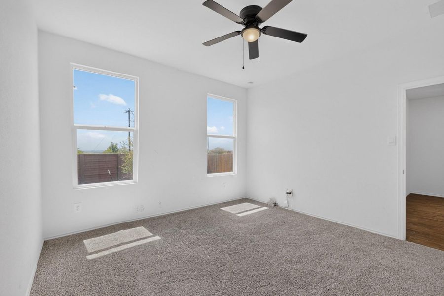 Natural light pours through dual windows in this carpeted bedroom. Natural light pours through dual windows in this carpeted bedroom.