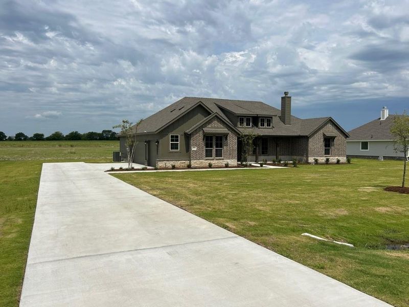 Front exterior of a new home in Terra Escalante, Blue Ridge, TX, highlighting curb appeal (Image 1). Front exterior of a new home in Terra Escalante, Blue Ridge, TX, highlighting curb appeal (Image 1).